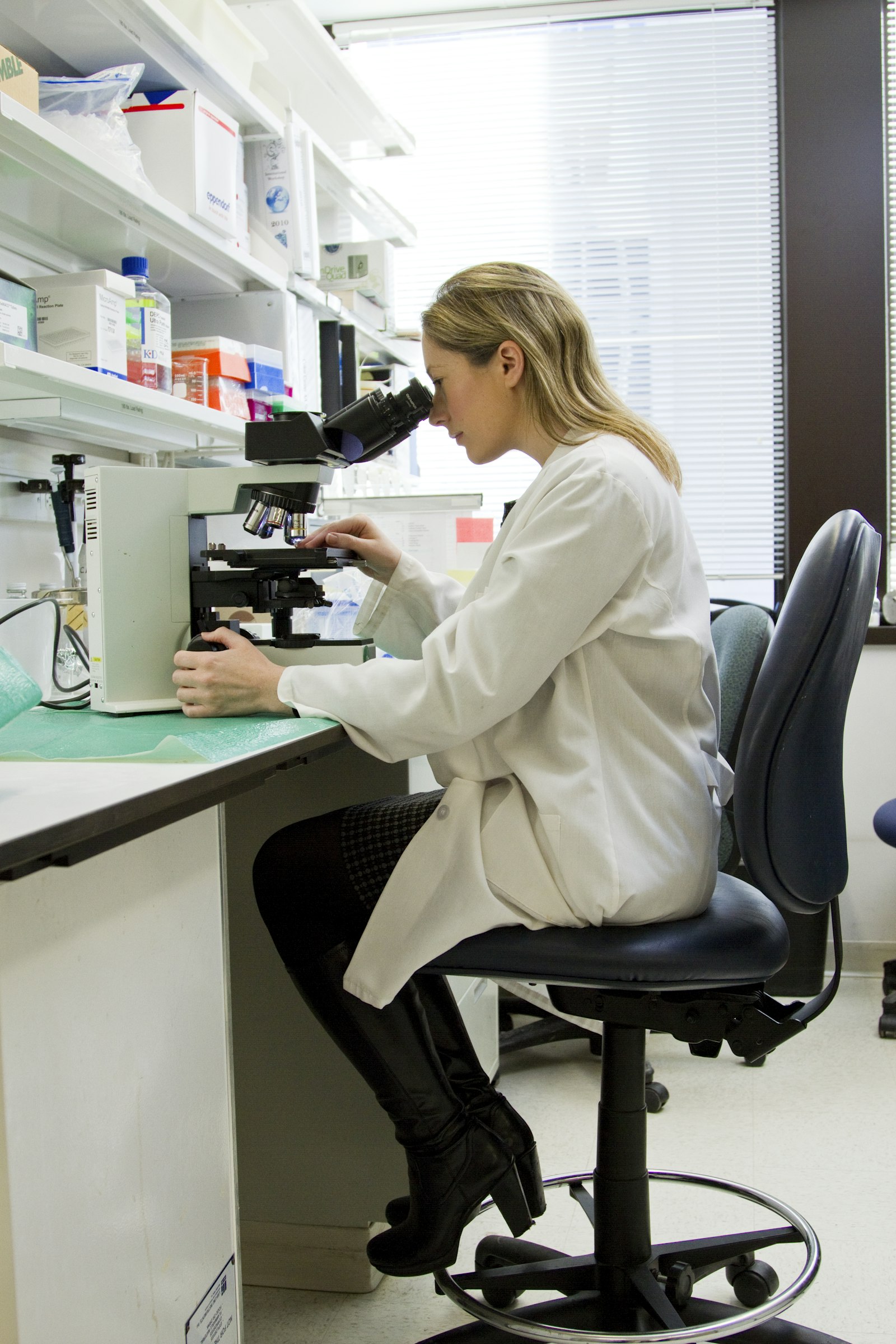 A quality-control analyst working at a laboratory microscope